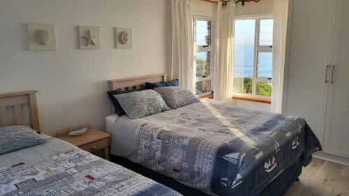 een slaapkamer met 2 bedden en uitzicht op de oceaan bij Seaside Tresure. in Mosselbaai