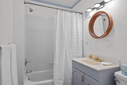 a white bathroom with a sink and a shower at Flamingo Park Bungalow! WALK TO DOWNTOWN WPB!! in West Palm Beach