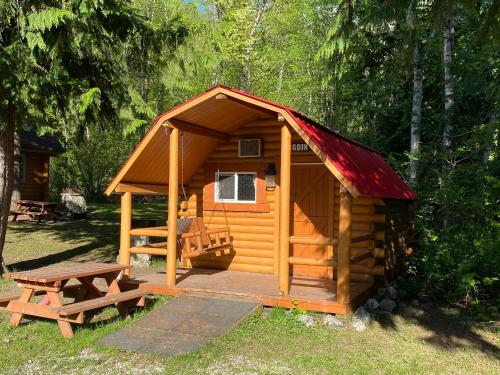 a wooden cabin with a table and a picnic table at Revelstoke RV & Cabin Resort in Revelstoke