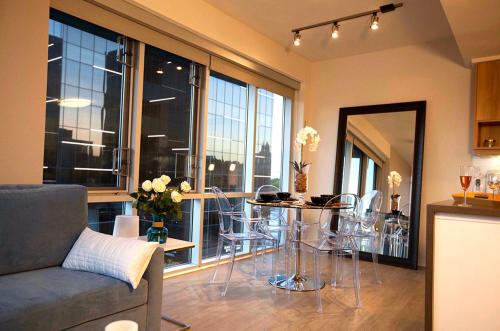 a living room with a table and chairs in front of a window at Masterpiece 2-Bedroom with Balcony, Pool, and Spa in Los Angeles