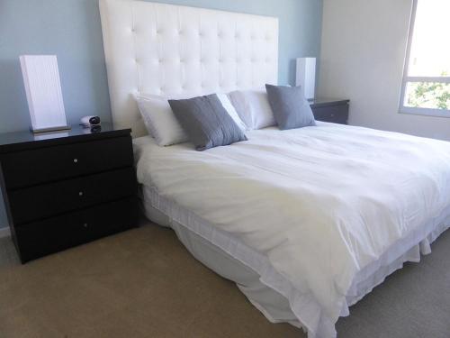 a bedroom with a large white bed and a dresser at Masterpiece 2-Bedroom with Balcony, Pool, and Spa in Los Angeles