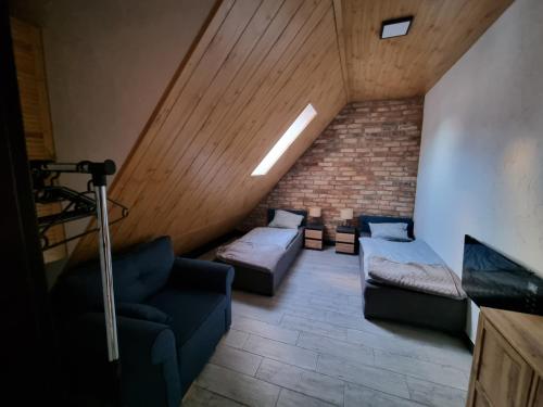 a attic room with two beds and a couch at Apartament Nova Kamienica 2 in Łagów