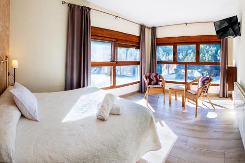 1 dormitorio con 1 cama, mesa y sillas en Hostal Avenjúcar, en Tolosa
