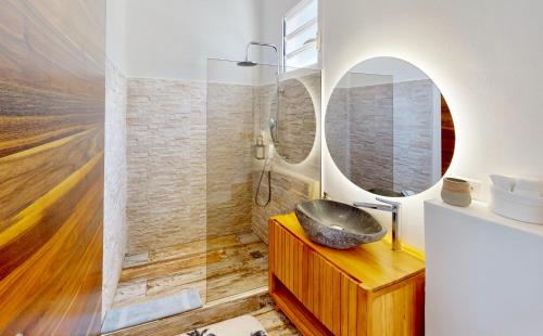 a bathroom with a sink and a mirror at SUNSEEKER SXM - Jardins Orient Bay - Appartement vue mer ou Studio vue Colline in Saint Martin