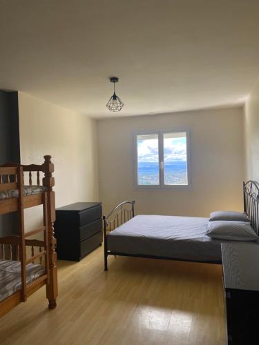 1 dormitorio con 2 camas y 2 ventanas en Grande maison récente avec vue en Saint-Hilaire