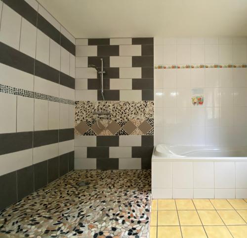 a bathroom with a bath tub and a sink at Vue panoramique & jacuzzi privé in Saint-Hilaire