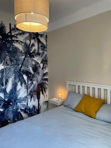 a bedroom with a bed with a tropical wallpaper at Maison rouge in Millau
