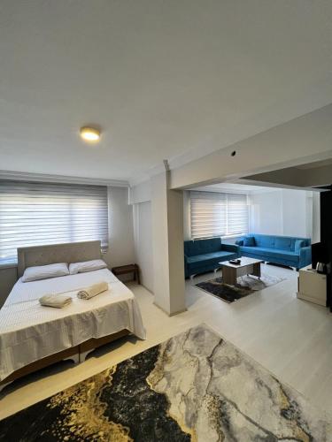 a bedroom with a large bed and a living room at Bahem Rezidans in Samsun