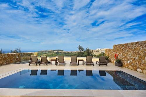 un patio con sillas y una piscina en Luxurious Maisonette with Pool, en Tal-Barmil