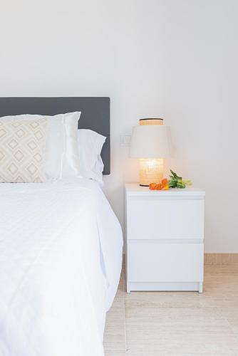 a bedroom with a white bed and a white nightstand at Salinas Mar y Playa in Roquetas de Mar