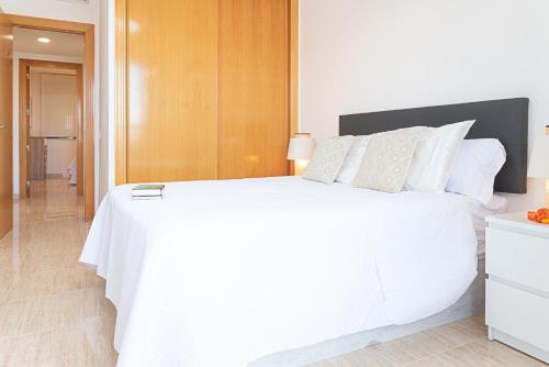 a bedroom with a large white bed with white pillows at Salinas Mar y Playa in Roquetas de Mar