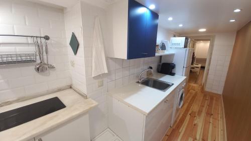 a small white kitchen with a sink and a counter at Alfama Home in Lisbon