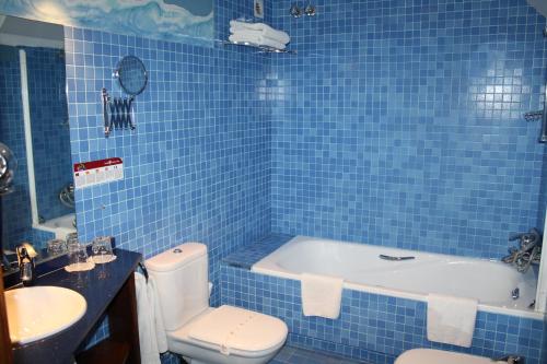 W wyłożonej niebieskimi kafelkami łazience znajduje się wanna i toaleta. w obiekcie Hotel Casa Estampa w mieście Escuñau