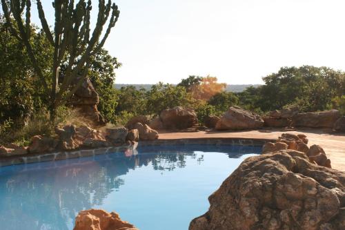 a swimming pool with blue water and rocks at Izintaba Private Game Reserve Waterberg in Vaalwater