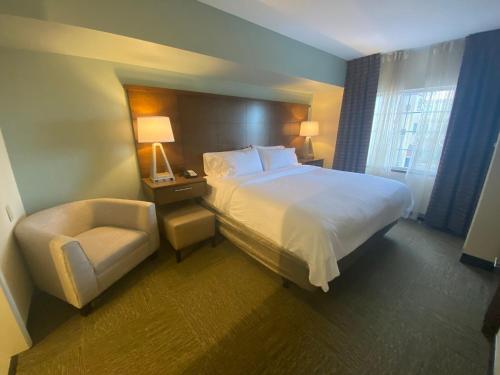 a hotel room with a bed and a chair at Staybridge Suites Great Falls by IHG in Great Falls