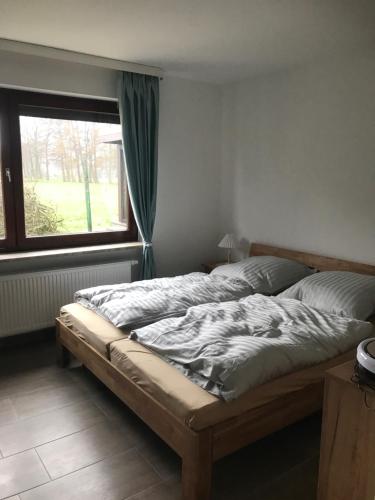 uma cama num quarto com uma janela em Ferienhaus am Heringskoop em Nordleda