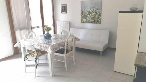 mesa de comedor con sillas y sofá en R07 Trilocale con terrazzo e garage, en Numana