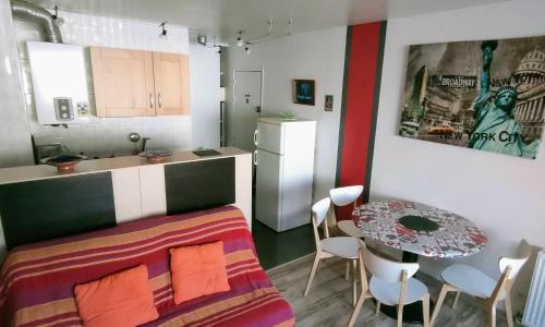 Cette chambre comprend un lit, une table et une cuisine. dans l'établissement Studio Sentosa bord de plage du Môle, au Cap d'Agde