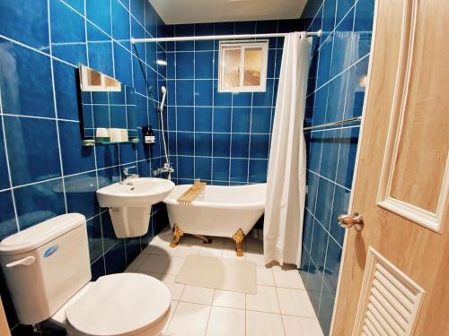 恆春的住宿－麋宿Mi House墾丁包棟，蓝色瓷砖浴室设有卫生间和水槽
