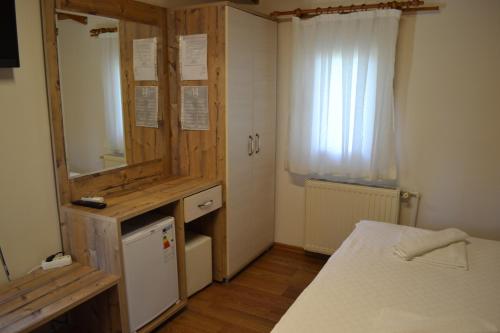 a small room with a bed and a mirror at Kervan Tatil Köyü in Edremit