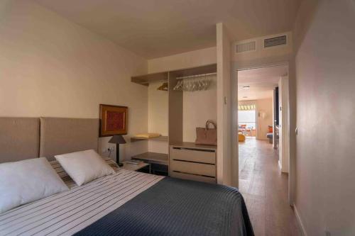 um quarto com uma cama grande e um corredor em Ático 1ª línea de playa en Puerto de Aguadulce em Almeria