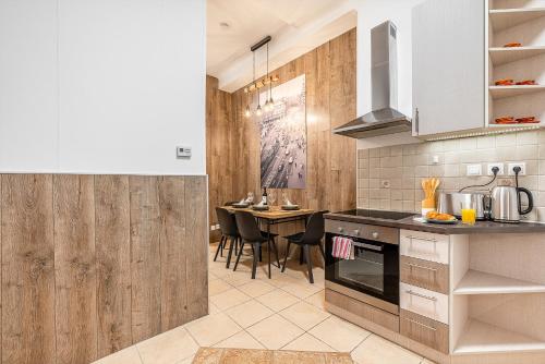 een keuken met houten wanden en een tafel met stoelen bij Budapest Then & Now Apartment in Boedapest