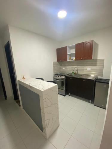 uma cozinha com electrodomésticos pretos e piso em azulejo branco em Cómodo apto 203 muy cerca a CENTRO COMERCIAL UNICENTRO CUCUTA em Cúcuta