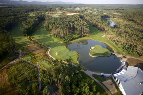 an aerial view of a golf course with a lake at Golf Villa Stella s bazénom in Šajdíkove Humence