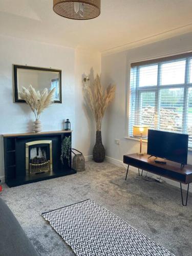 un salon avec une cheminée et une table dans l'établissement Park View Apartment, à Bridlington