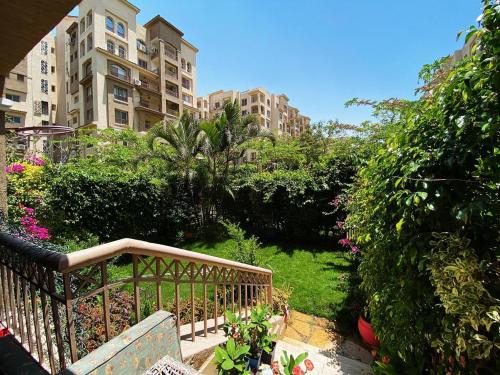 un jardin avec un banc et quelques buissons et bâtiments dans l'établissement مدينتي, au Caire