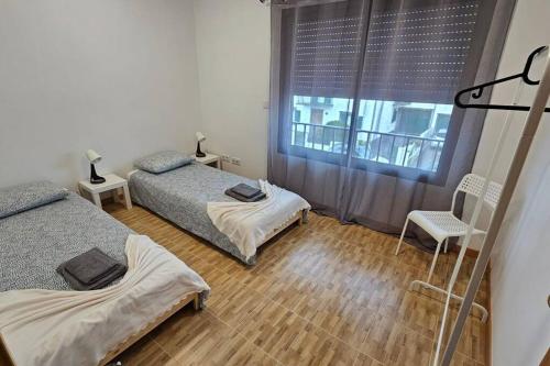 a bedroom with two beds and a window at Casa da Relva in Ponta Delgada