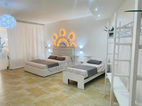 a bedroom with two beds and a ladder at Dimora al Mare in Villanova di Ostuni