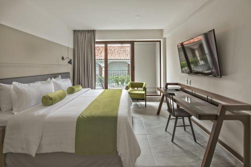 ein Hotelzimmer mit einem großen Bett und einem Schreibtisch in der Unterkunft Gamma Orizaba Grand Hotel de France in Orizaba