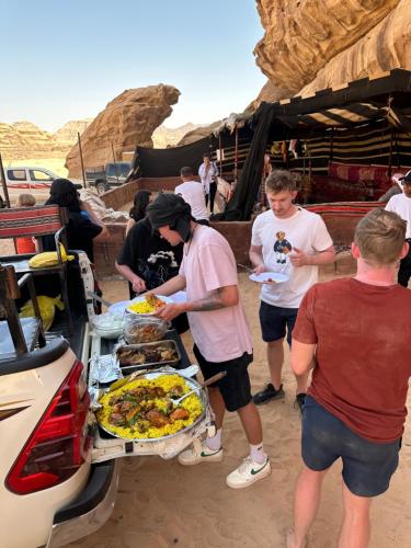a group of people standing around a buffet of food at Panorama Luxury Camp in Wadi Rum