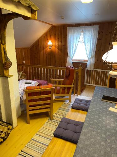 a room with a bedroom with a bed and a chair at Bjørkely gård in Hidra