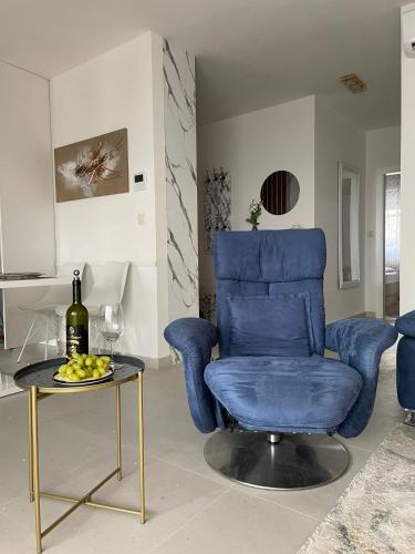 a living room with a blue chair and a table at Mali Raj Makarska in Makarska