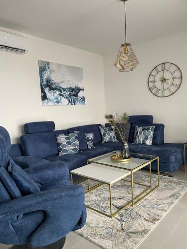a living room with a blue couch and a table at Mali Raj Makarska in Makarska