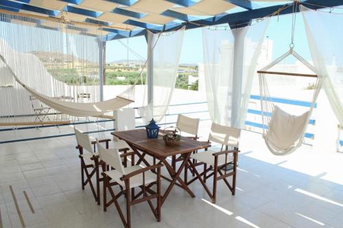 a dining room with a wooden table and chairs at Klironomos Apartments Logaras in Logaras