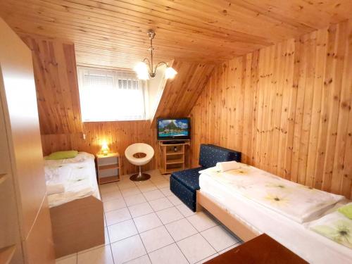 Zimmer mit 2 Betten und einem TV. in der Unterkunft Patkó fogadó in Hajdúszoboszló