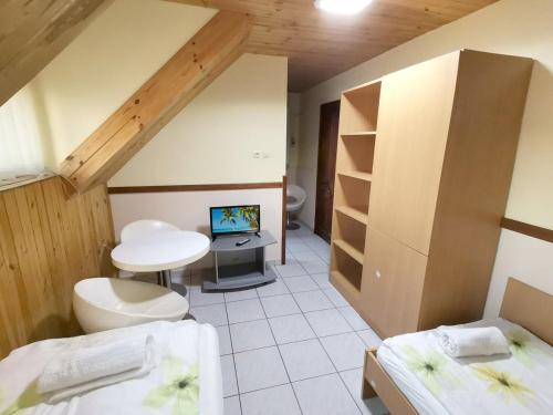 a room with two beds and a television in it at Patkó fogadó in Hajdúszoboszló