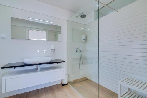 een badkamer met een glazen douche en een wastafel bij FormosaFuzeta Seaview @Homesbyfc in Fuzeta