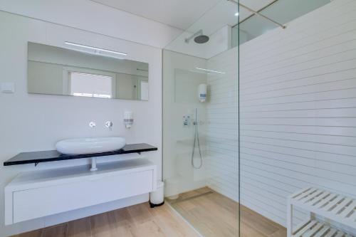 a bathroom with a glass shower and a sink at FormosaFuzeta Seaview @Homesbyfc in Fuzeta