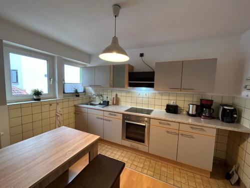 a kitchen with white cabinets and a wooden table at Paradiesisch Wohnen Bad Schwalbach in Bad Schwalbach