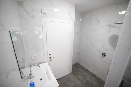 a white bathroom with a shower and a sink at חופשה בטבריה בבית ענק ל 8 אנשים גדול וחדש in Tiberias