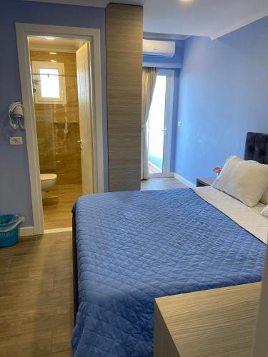 a blue bedroom with a bed and a bathroom at Persephone in Himare