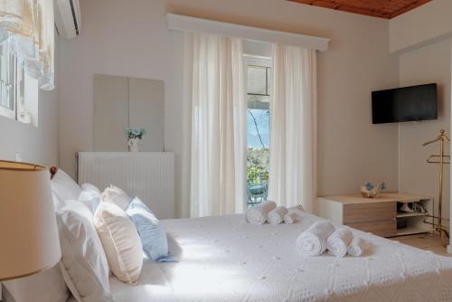 una camera da letto con un letto bianco e asciugamani di Heliotropio a Kalamákion