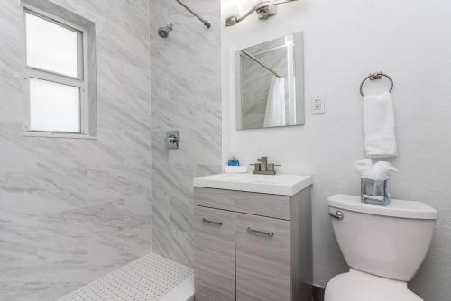 biała łazienka z toaletą i umywalką w obiekcie La Vida Delray 1 w mieście Delray Beach
