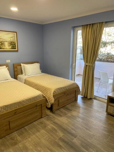 a bedroom with two beds and a sliding glass door at Persephone in Himare