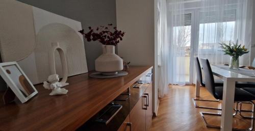 eine Küche mit einer Vase auf einer Holztheke mit einem Tisch in der Unterkunft Apartman Via Casa in Vinkovci