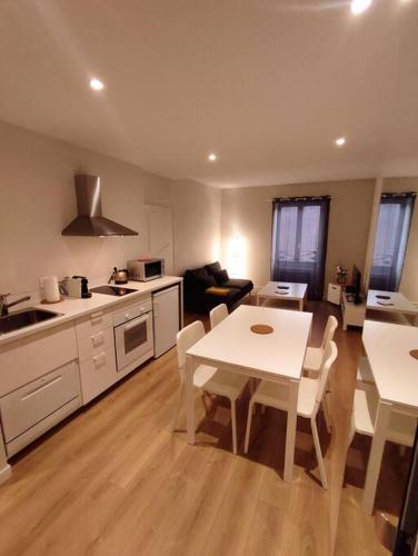 uma cozinha e sala de estar com mesa e cadeiras em Appartement hyper centre em Lons-le-Saunier